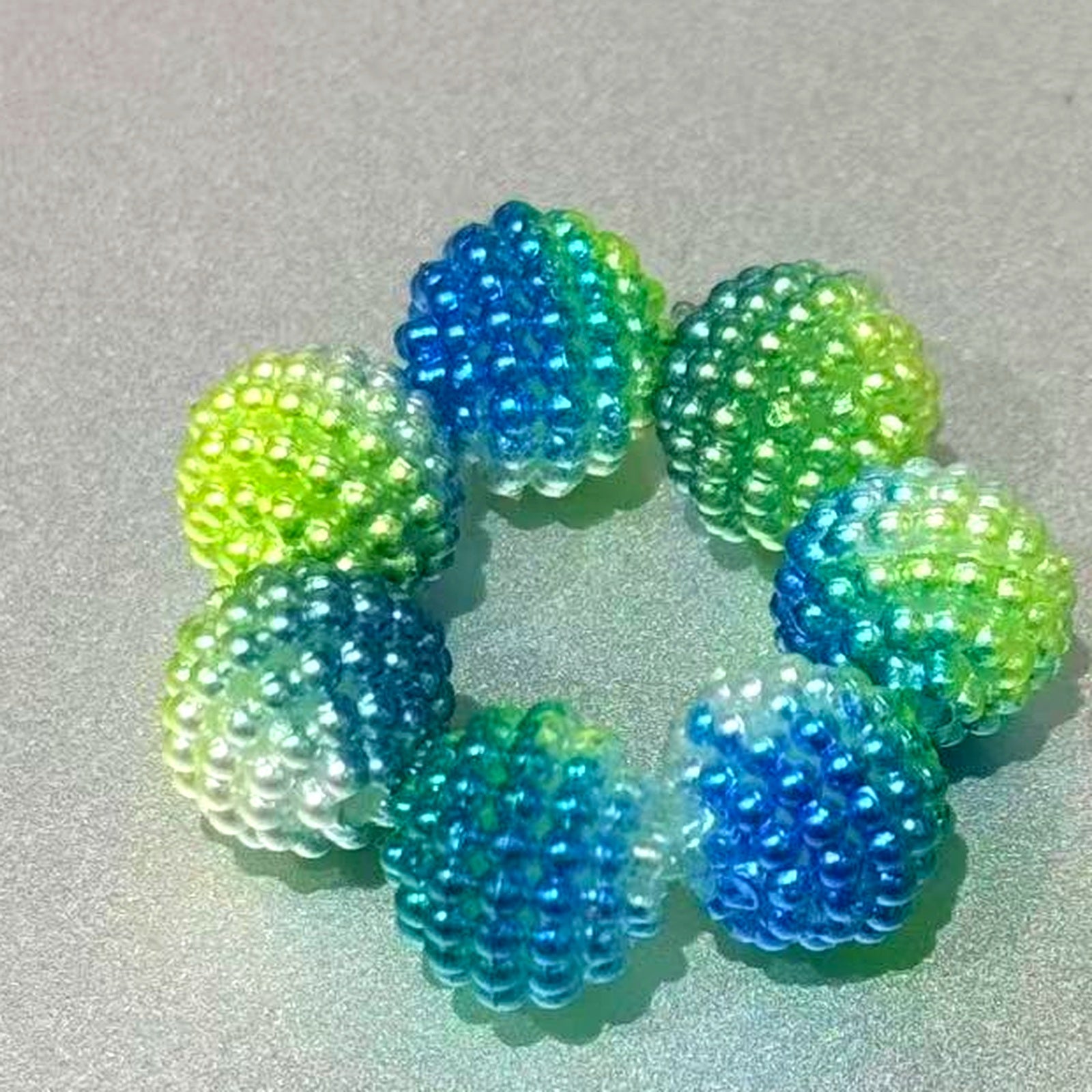Berry bead DIY bracelet inspiration set on a silver-gray surface